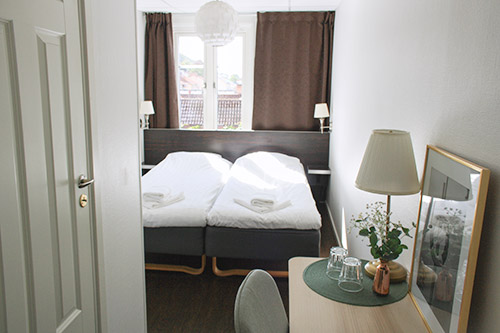 Bild på ett fräscht hotellrum i vitt med en svart säng